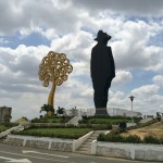 large silhouette stands next to a yellow metal tree